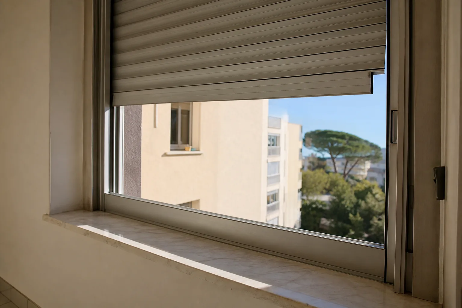 Volet roulant en aluminium arrêté à mi-course sur une façade claire, une lame légèrement sortie de sa coulisse